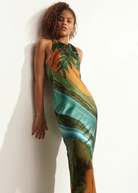 Model wearing KABE SHOP INC Magdalena long silk maxi dress with halter neckline and landscape print