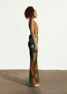 KABE SHOP INC Magdalena long silk maxi dress with halter neckline and abstract landscape print on a model side view