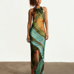 Model wearing KABE SHOP INC Magdalena long silk maxi dress with halter neckline and landscape print