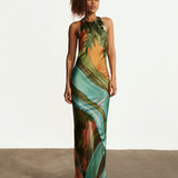 Model wearing KABE SHOP INC Magdalena long silk maxi dress with halter neckline and landscape print