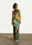 Model wearing KABE SHOP INC Magdalena long silk maxi dress with halter neckline and landscape print