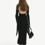KABE SHOP INC Maltha midi skirt in black, featuring a sculptural silhouette and fluid drape on a model from behind.