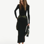 Model wearing KABE SHOP INC Maltha midi skirt in black with a green patterned waist detail and side slit