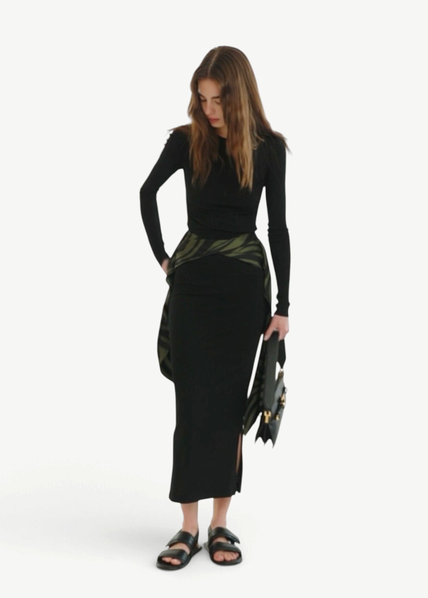 Model wearing KABE SHOP INC Maltha midi skirt in black with a green patterned waist detail and side slit