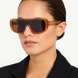 KABE SHOP INC Jacquemus Masco shield sunglasses in caramel acetate with brown lenses worn by a woman in a black blazer