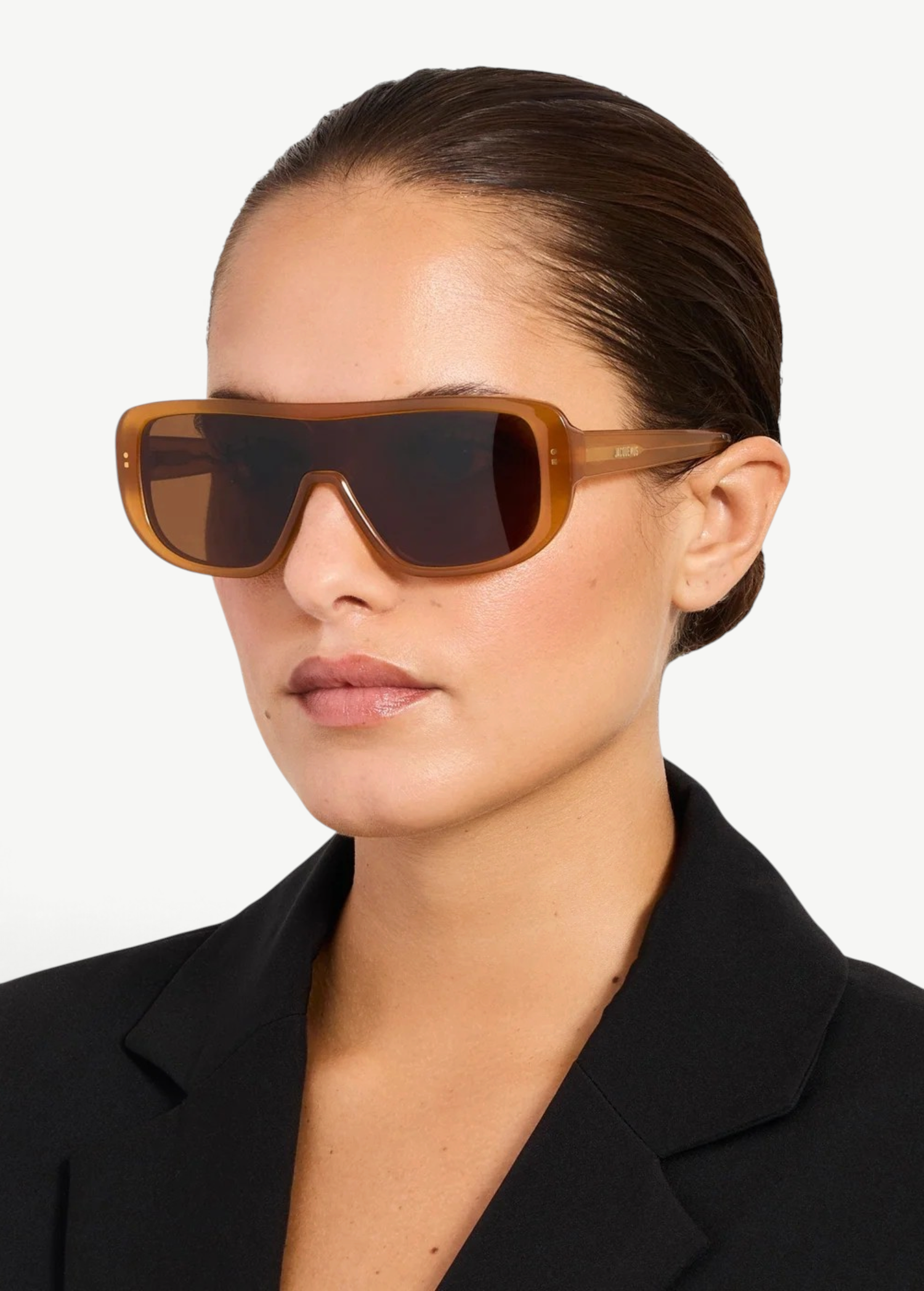 KABE SHOP INC Jacquemus Masco shield sunglasses in caramel acetate with brown lenses worn by a woman in a black blazer