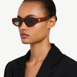 Model wearing KABE SHOP INC Maya sunglasses with a light brown acetate frame and tinted lenses in a side profile view.