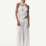 Model wearing KABE SHOP INC Menorca trousers in white cotton with intricate lace detailing and a relaxed fit.