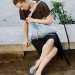 KABE SHOP INC Deiji Studios metallic knit chain bag with drawstring pouch worn by a woman sitting on a stone bench