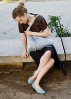 KABE SHOP INC Deiji Studios metallic knit chain bag with drawstring pouch worn by a woman sitting on a stone bench