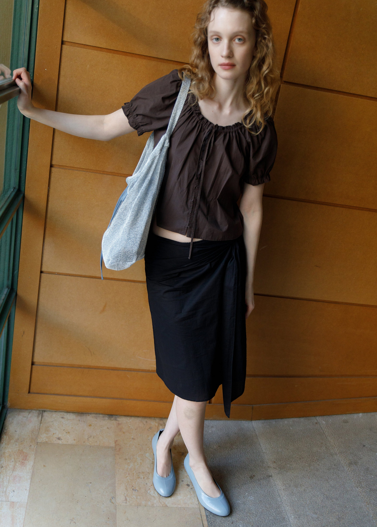 KABE SHOP INC Deiji Studios metallic knit chain bag with drawstring pouch worn by a model in a brown top and skirt