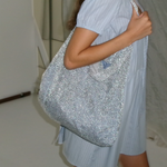 KABE SHOP INC Deiji Studios Chain Bag in metallic silver knit worn over the shoulder with a light blue dress
