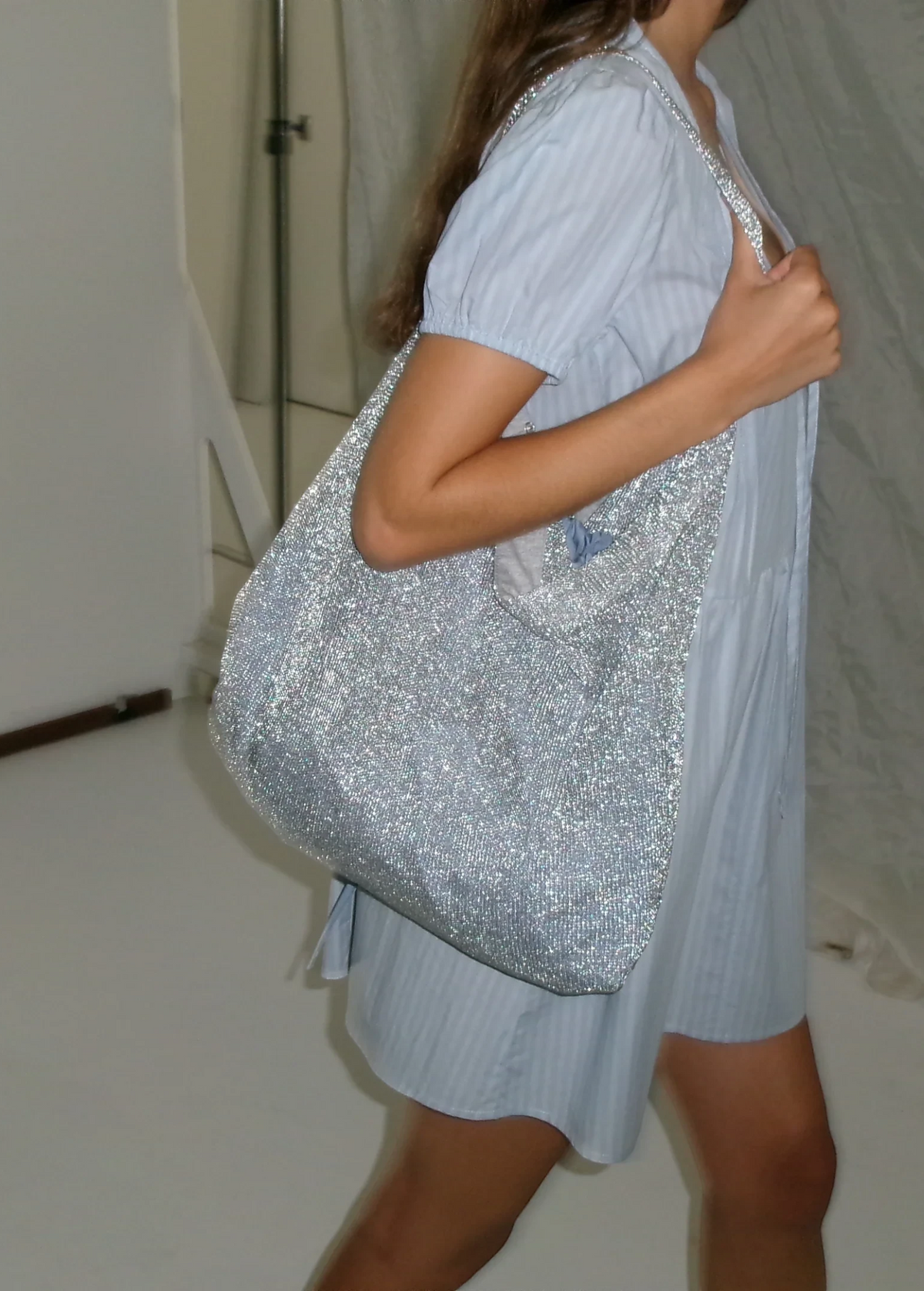 KABE SHOP INC Deiji Studios Chain Bag in metallic silver knit worn over the shoulder with a light blue dress