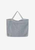 KABE SHOP INC Deiji Studios metallic silver knit shoulder bag with an organic cotton drawstring pouch interior.