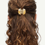 KABE SHOP INC mini claw hair clip in cream and brown bio-acetate holding curly hair in a half-up style