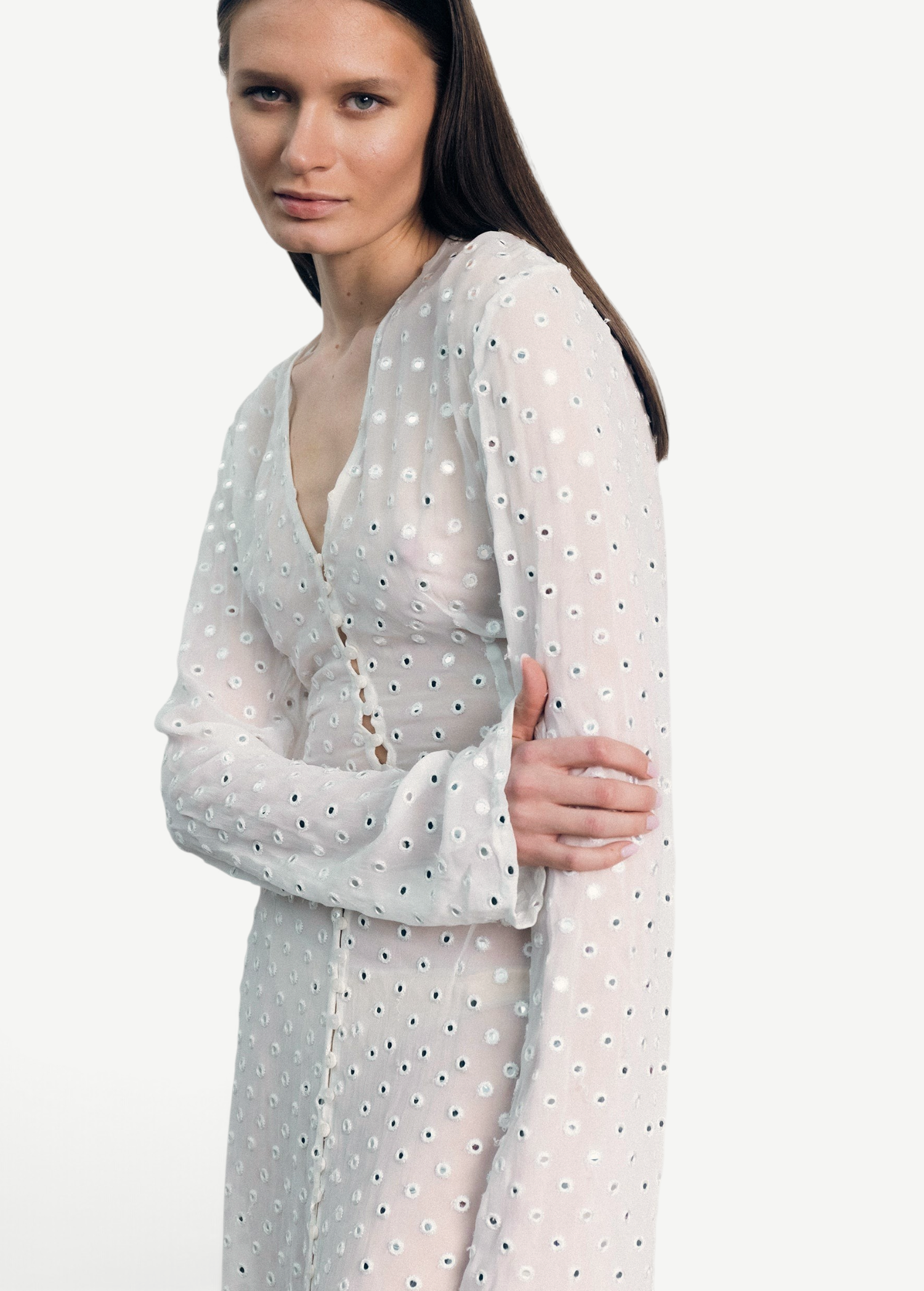 Model wearing a KABE SHOP INC sheer white Mirror Dress with delicate silver circular embellishments and long sleeves.