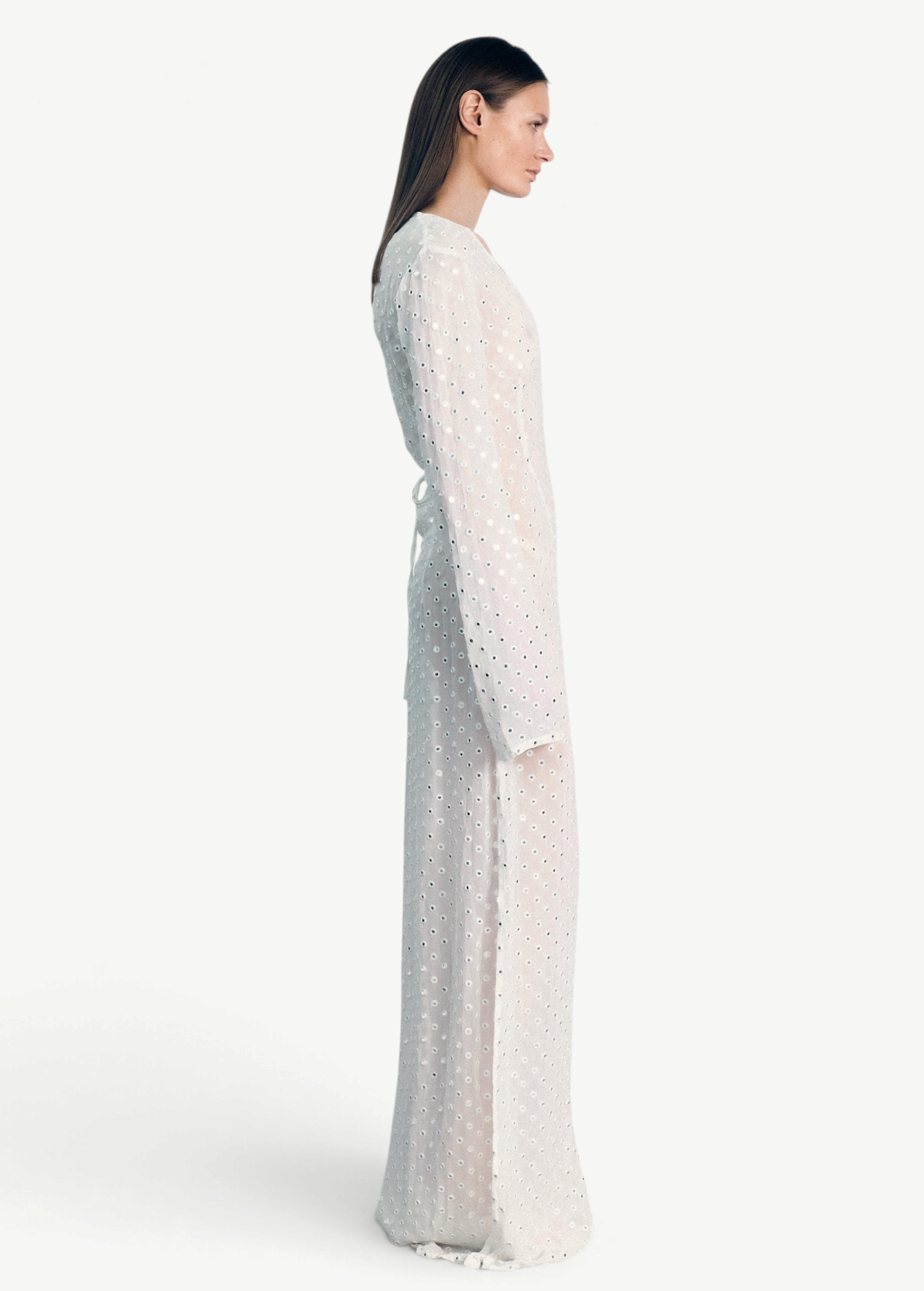 Model wearing a KABE SHOP INC Mirror dress in sheer white fabric with delicate silver embellishments and long sleeves.