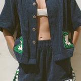 KABE SHOP INC navy organic cotton towelling boxy shirt with a handwoven green and white crochet pocket detail.