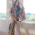 KABE SHOP INC Nera wide leg pants featuring a brown and white tribal ikat print, worn with a matching button-up shirt.