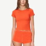 KABE SHOP INC Mini Track Short in bright orange terry cloth, featuring a slim fit and mini length on a model.