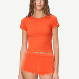 KABE SHOP INC Mini Track Short in bright orange terry cloth, featuring a slim fit and mini length on a model.