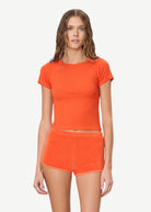 KABE SHOP INC Mini Track Short in bright orange terry cloth, featuring a slim fit and mini length on a model.