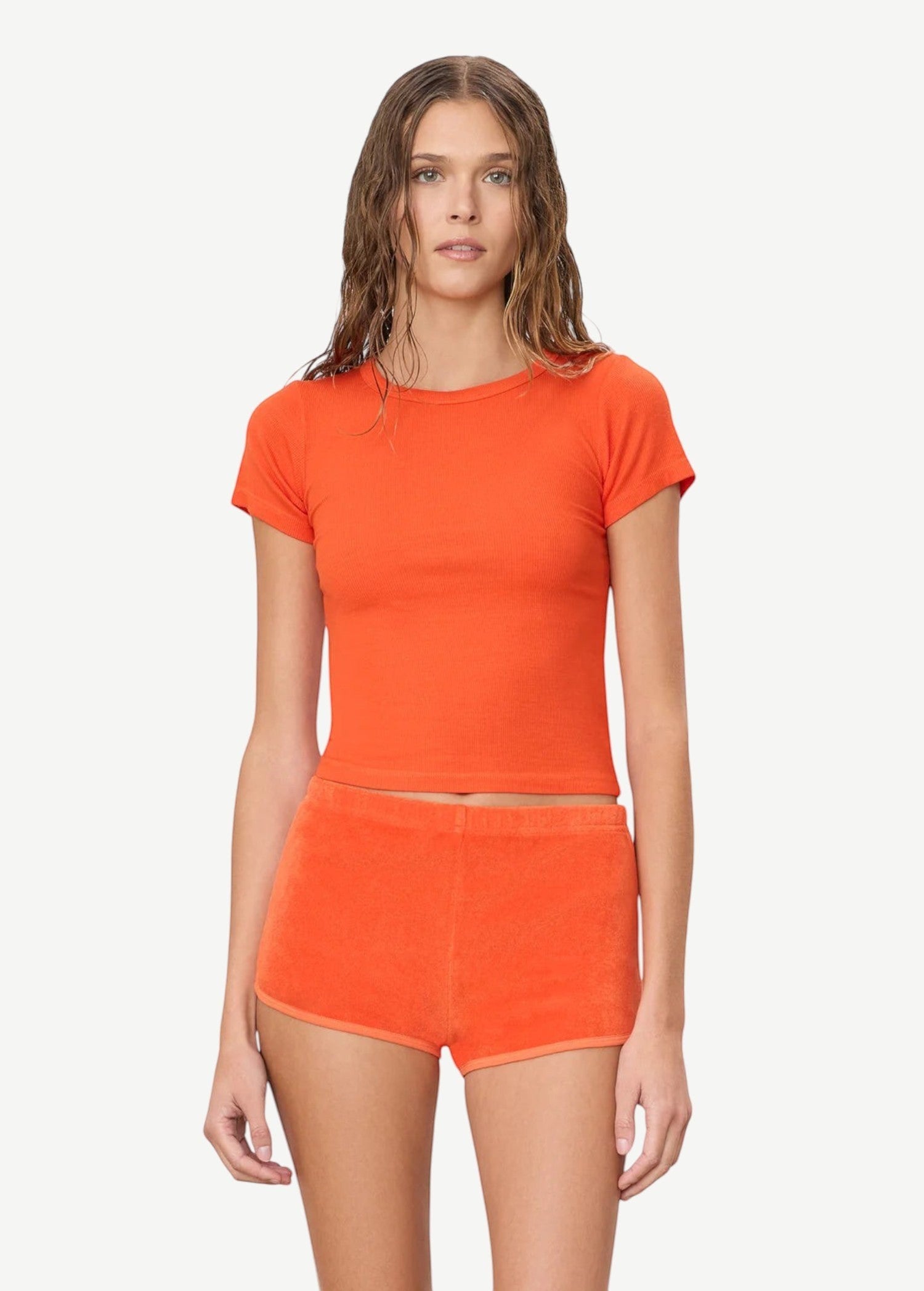 KABE SHOP INC Mini Track Short in bright orange terry cloth, featuring a slim fit and mini length on a model.