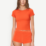 KABE SHOP INC Mini Track Short in bright orange terry cloth, featuring a slim fit and mini length on a model.