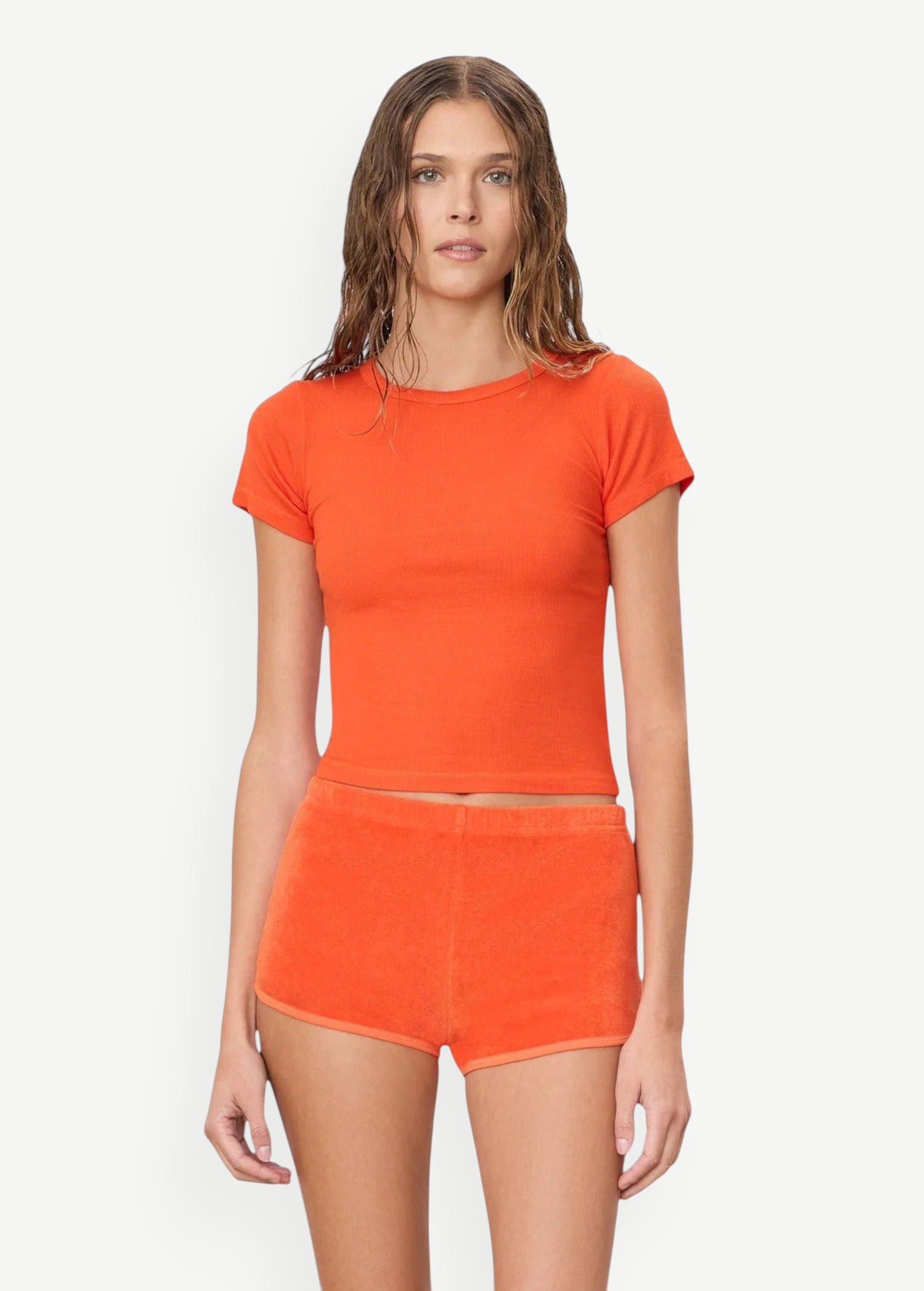 KABE SHOP INC Mini Track Short in bright orange terry cloth, featuring a slim fit and mini length on a model.
