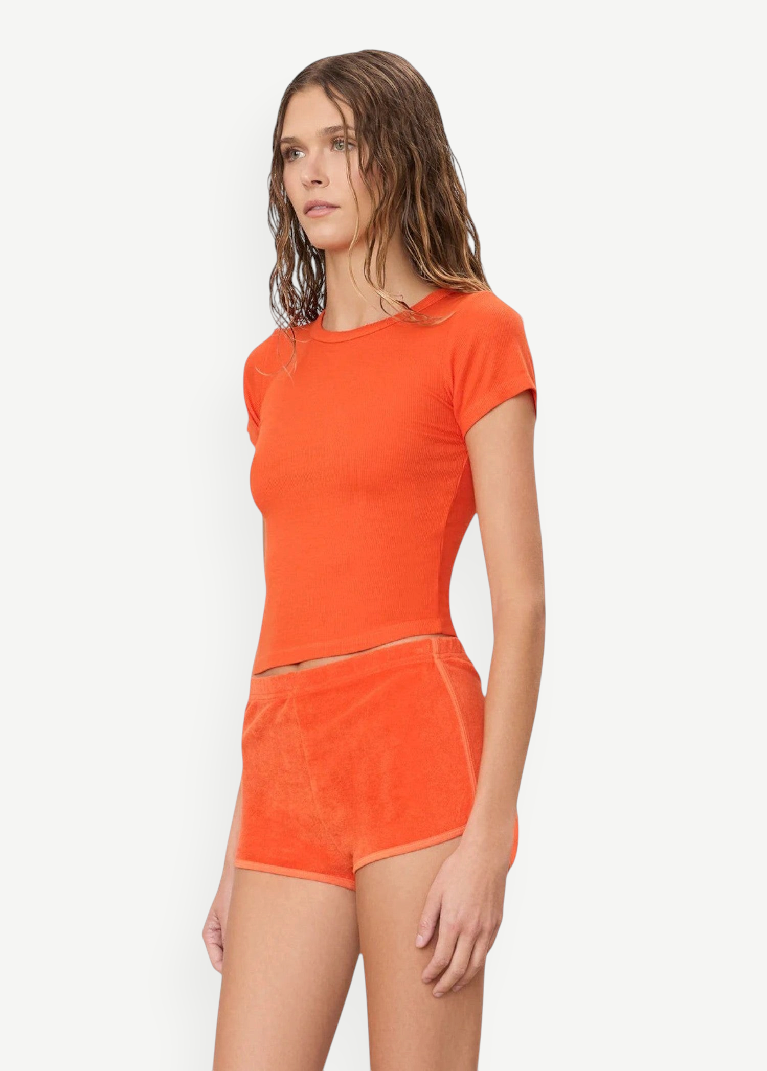 KABE SHOP INC model wearing orange terry cloth mini track shorts and a matching slim-fit ribbed t-shirt