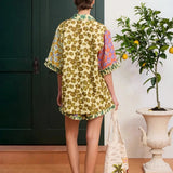 KABE SHOP INC Patty shirt with a yellow floral print and mixed pattern sleeves, worn with matching shorts.