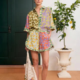 Model wearing KABE SHOP INC Patty Shirt with matching floral print shorts and a crochet tote bag