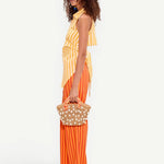 Model wearing KABE SHOP INC Pia Poplin Pant in fruit punch orange stripe with a matching yellow striped top