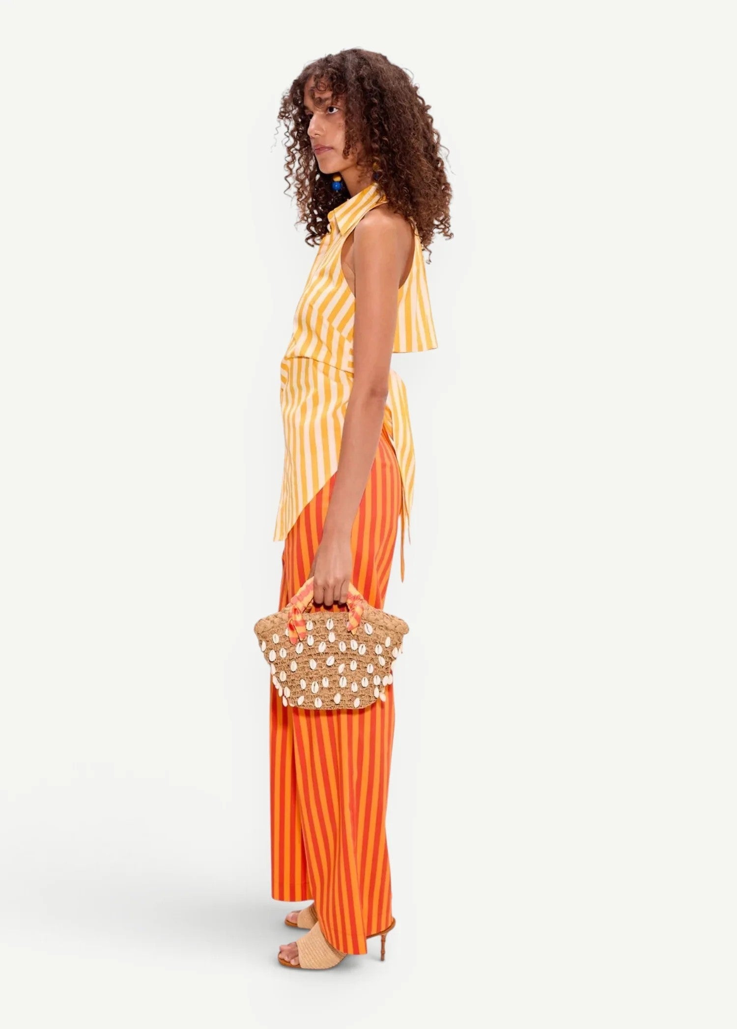 Model wearing KABE SHOP INC Pia Poplin Pant in fruit punch orange stripe with a matching yellow striped top