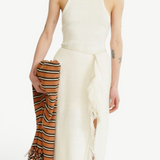 KABE SHOP INC Rayen dress in cream with a racerback neckline, side slit, and fringe detail, held with a striped scarf