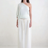 Model wearing KABE SHOP INC Rhea maxi skirt in white with an adjustable drawstring waistband and clean silhouette