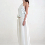 Model wearing a KABE SHOP INC Rhea maxi skirt in white with an adjustable drawstring waistband, side profile view.
