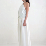 Model wearing a KABE SHOP INC Rhea maxi skirt in white with an adjustable drawstring waistband, side profile view.