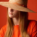 KABE SHOP INC Sangay wide brim straw hat with orange grid pattern worn by a model against a vibrant orange background