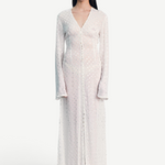 Model wearing a KABE SHOP INC sheer white long-sleeve Mirror Dress with delicate silver embellishments