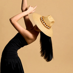 KABE SHOP INC Sine wide brim straw hat with wooden bead detail worn by a model in a black dress against a tan background