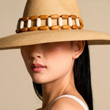 KABE SHOP INC Sine wide brim straw hat with decorative wooden and white bead band worn by a woman