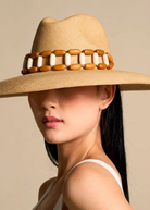KABE SHOP INC Sine wide brim straw hat with decorative wooden and white bead band worn by a woman