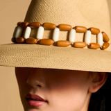 KABE SHOP INC Sine wide brim straw hat in beige with a decorative brown and white beaded band on a model