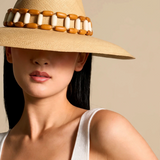 KABE SHOP INC Sine wide brim straw hat with a decorative wooden bead band worn by a woman in a white tank top