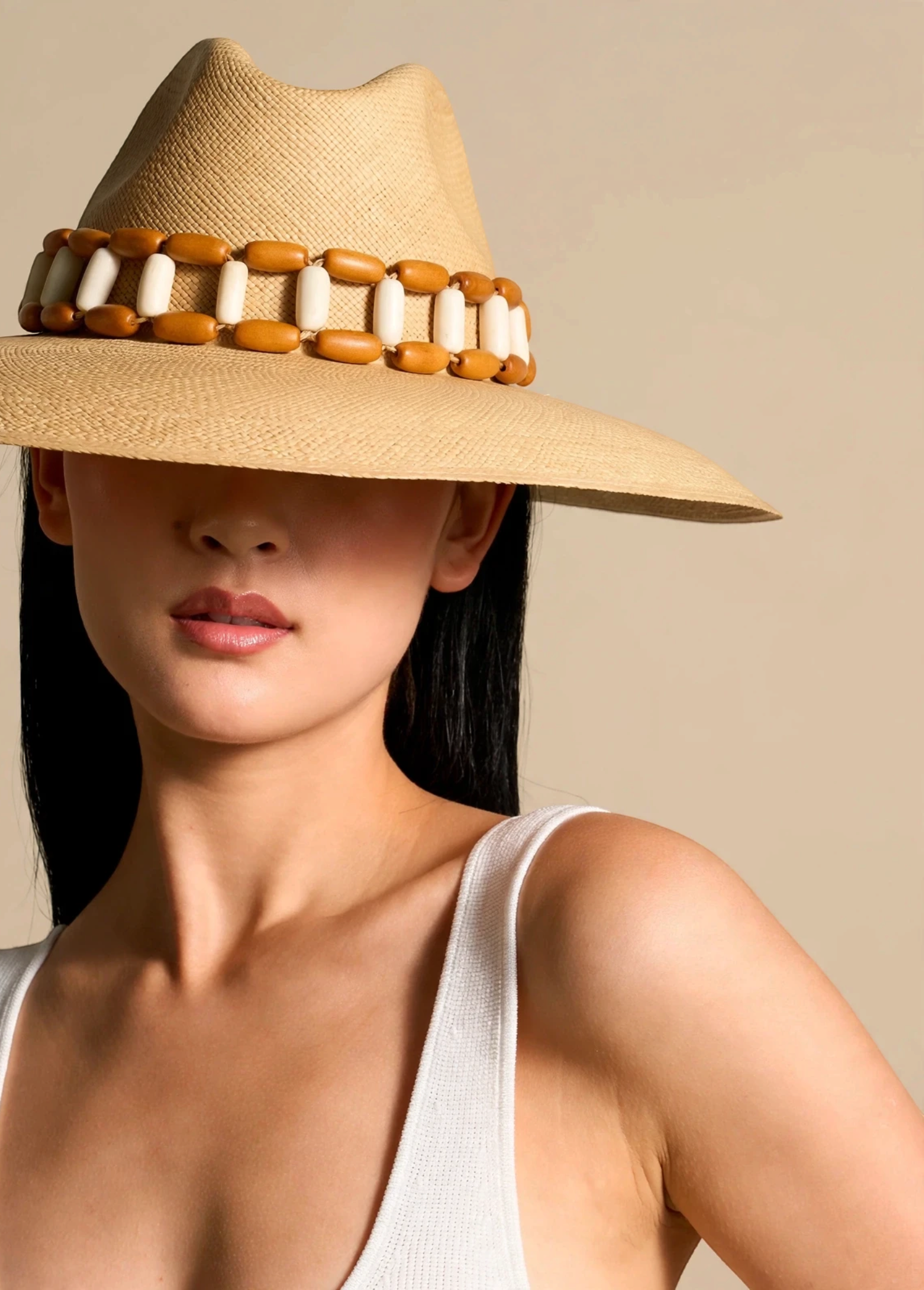 KABE SHOP INC Sine wide brim straw hat with a decorative wooden bead band worn by a woman in a white tank top