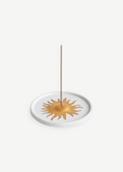 KABE SHOP INC Soleil porcelain incense holder with a gold hand-painted sun motif on a white circular base