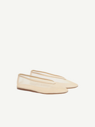 A pair of beige Luna Slipper Shoes, featuring a minimalist design with a slightly pointed toe, thin soles, and a low-cut silhouette crafted from glossy patent leather, displayed on a white background.