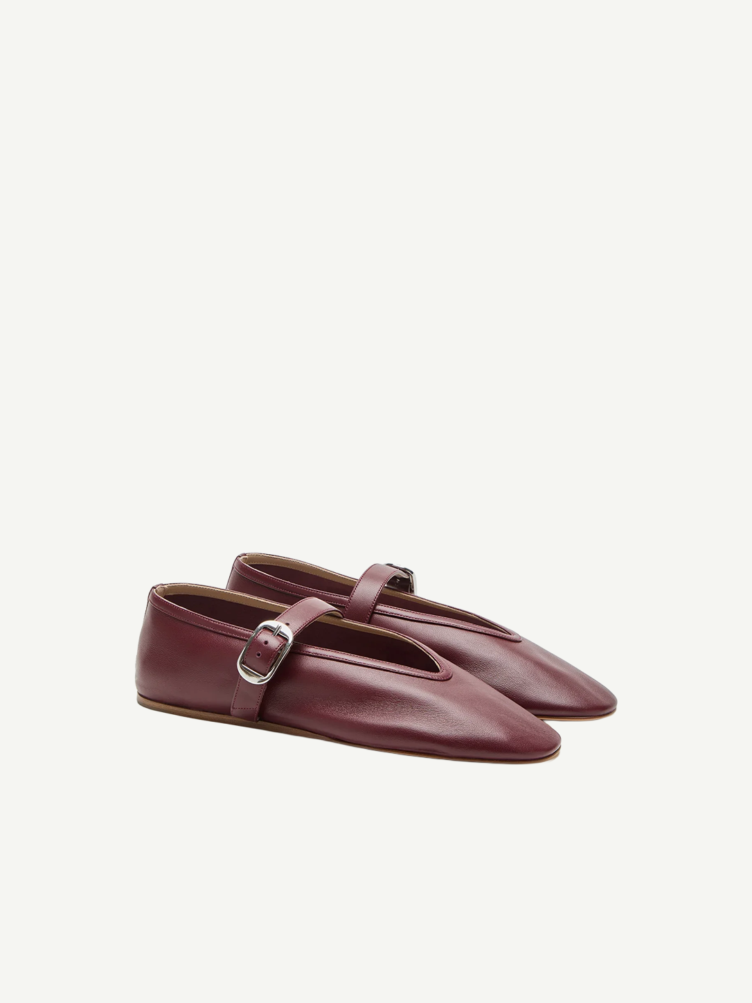 A pair of Stella Slipper Leather Shoes in rouge leather, featuring a strap with a polished buckle and a split front design, displayed against a plain white background.