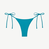 The Praia Bottom is a bright blue bikini bottom featuring a high-cut front and adjustable side string ties, crafted from regenerated nylon for an eco-friendly swimwear choice and displayed against a plain white background.